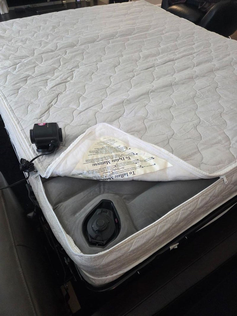 Close-up of a Crate & Barrel sleeper sofa mattress showing an air valve and inflation mechanism under the cover.