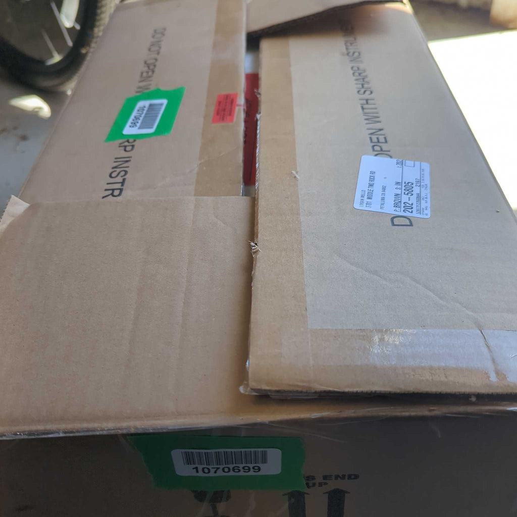 1. Cardboard boxes containing lighting fixtures stacked with shipping labels and green barcode stickers visible.
