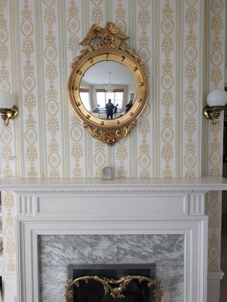 a mirror on a wall above a fireplace.