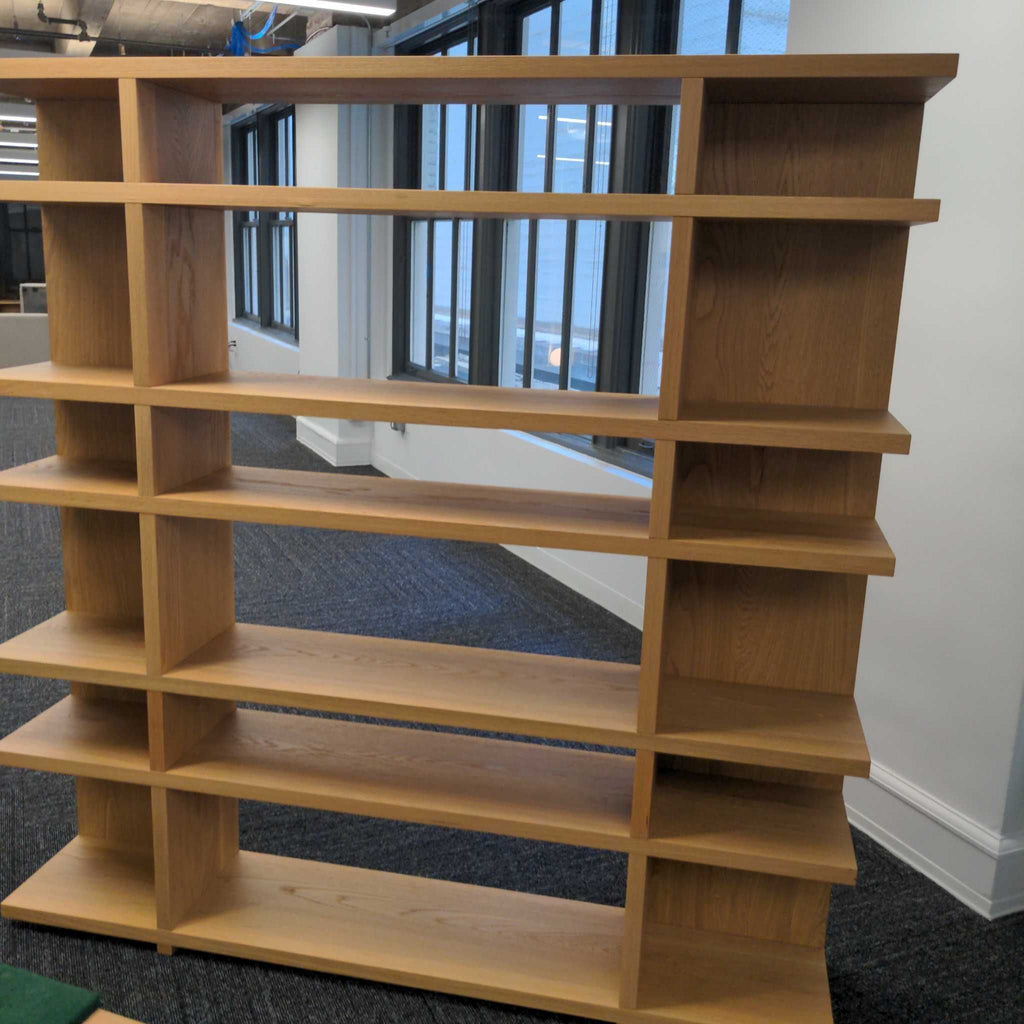 1. Minimalist wooden bookshelf with three shelves, holding various books and small decor.  
