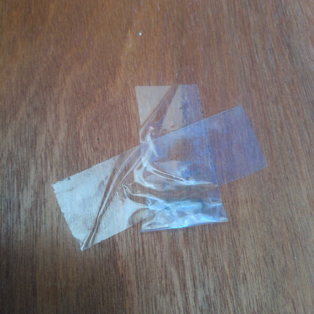 3. Screw taped to a dresser surface with two pieces of clear tape, secured for safekeeping.