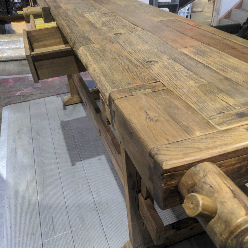 2. Close-up of a rustic wooden workbench featuring sturdy legs and drawers, highlighting aged wood texture.