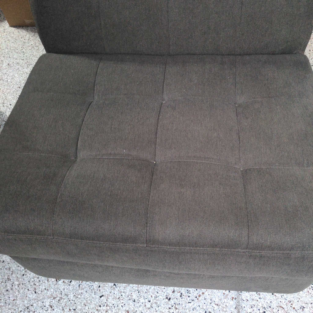 2. Top-down view of a dark gray Jonathan Louis lounge chair, showing its tufted fabric seat and back.