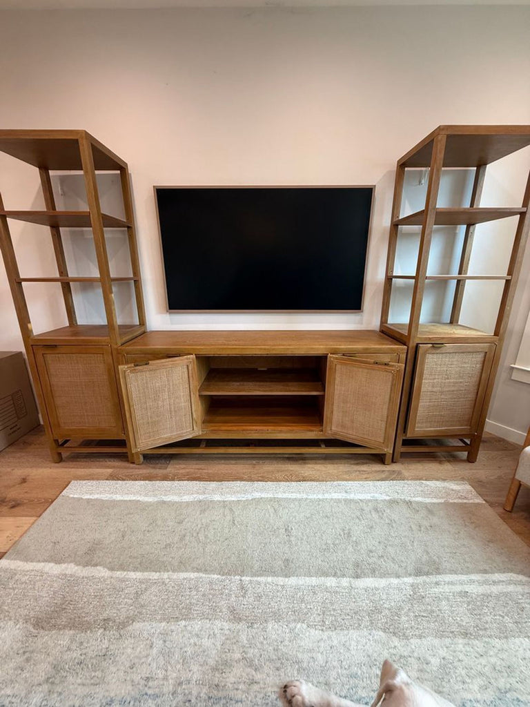 1. Crate & Barrel Entertainment Center with open and closed shelving flanking a TV, wood and rattan finish.