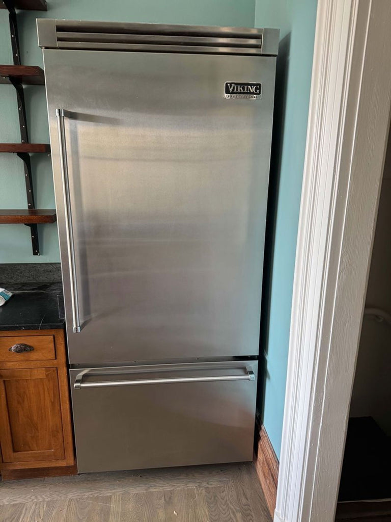 Stainless steel Viking Professional refrigerator with bottom freezer drawer in a kitchen setting.