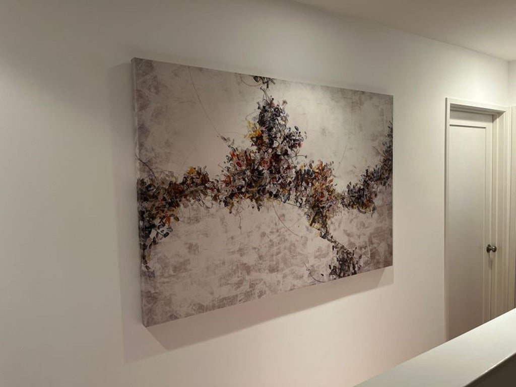 1. Abstract painting with swirling earth-toned patterns on a light background, mounted on a white hallway wall.
