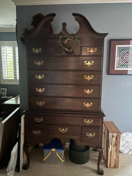 1. Tall, dark wood Pennsylvania House dresser with brass handles and decorative top, against a blue wall.  