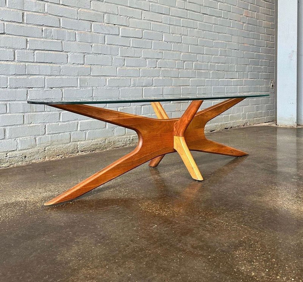 Mid-century modern Adrian Pearsall coffee table with sculpted wooden base and oval glass top, side view.