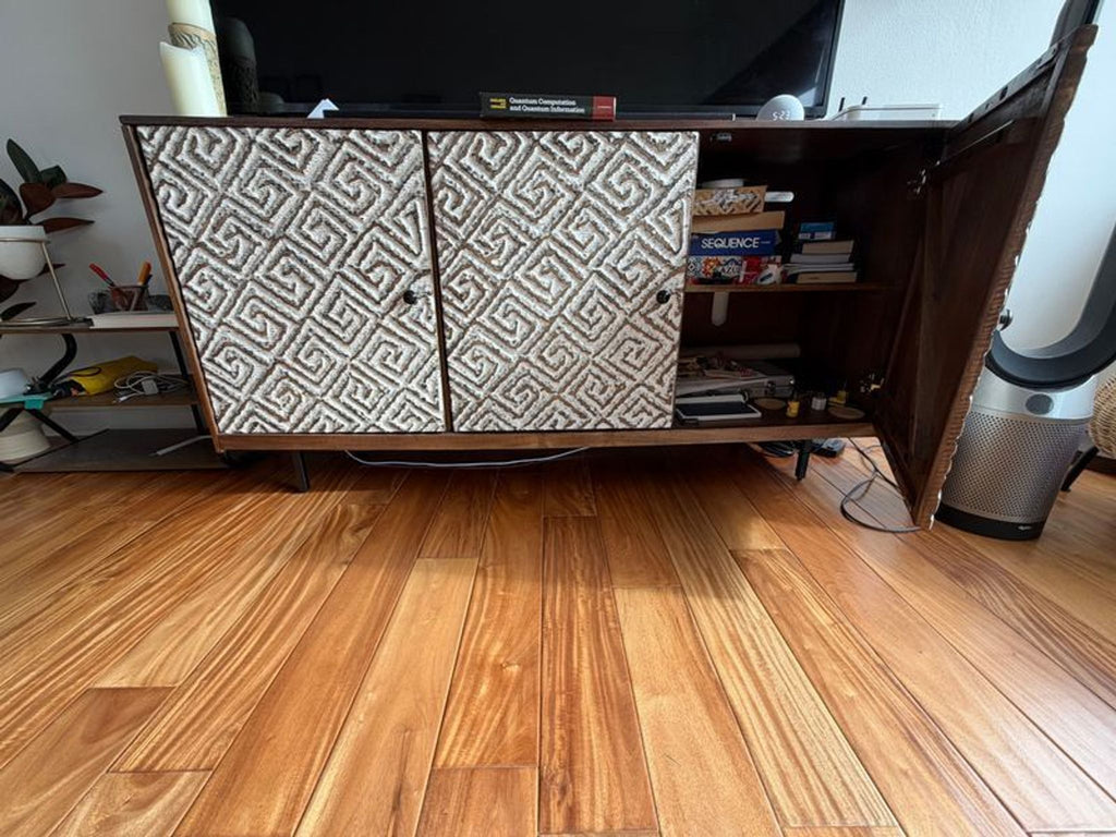 1. Ashley Furniture entertainment center with textured patterned doors, one open to reveal shelves with books and gadgets.