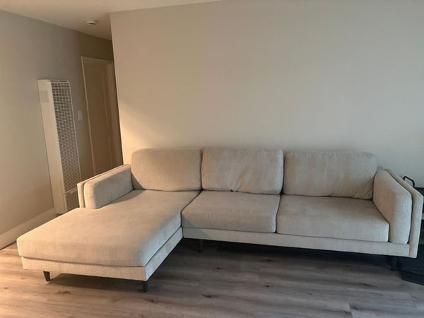 1. Modern Living Spaces sectional sofa with L-shape, upholstered in light grey fabric, in a spacious living room.