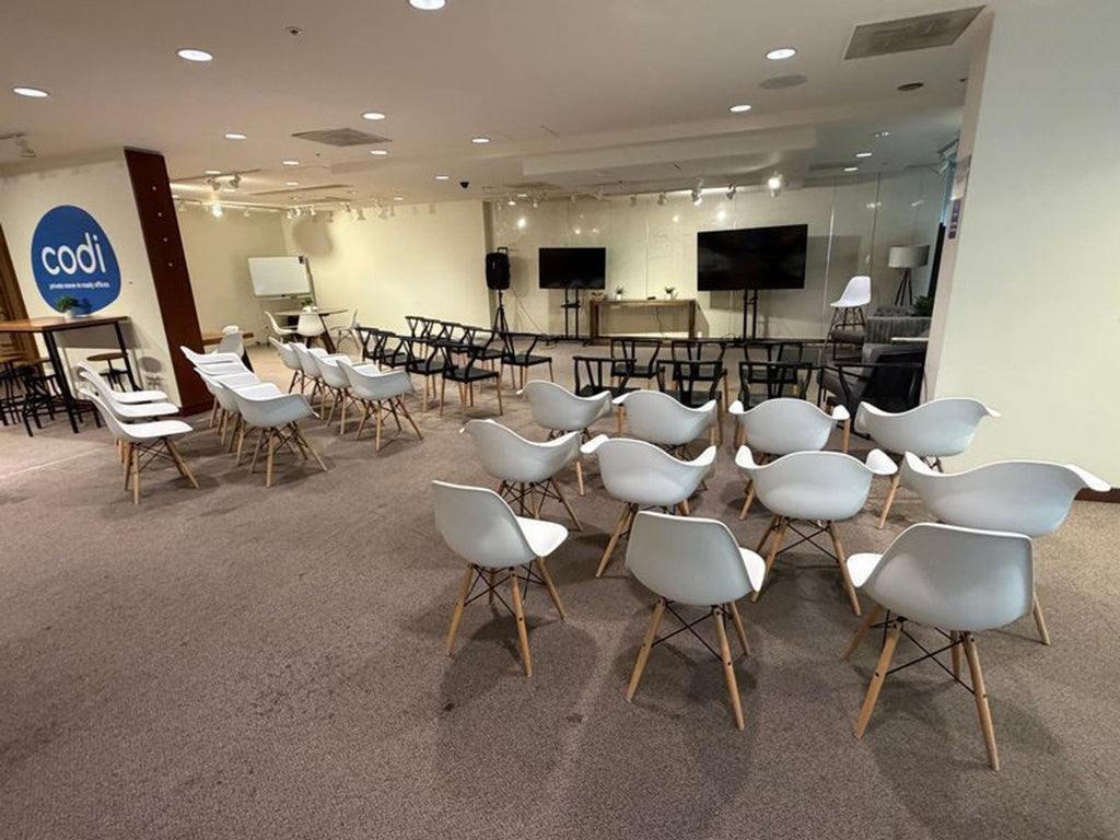 2. Contemporary dining chairs with white and black seats and wooden legs set up in a conference area.