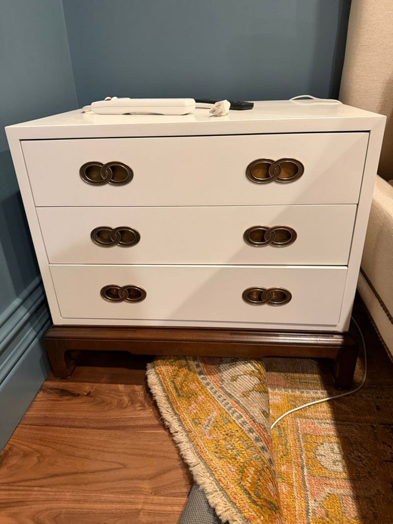 Classic white Henredon end tables featuring three drawers, brass pulls, and warm wood contrast.