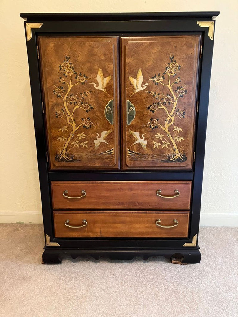 1. Elegant armoire with two doors featuring crane and floral designs, two wood drawers, and brass handles. Hutch & Armoire.
