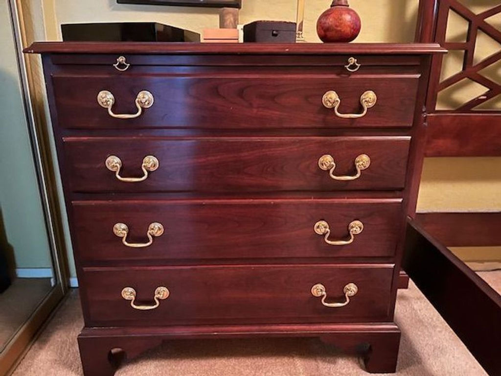 1. Stickley end table with four deep cherry wood drawers and brass handles, shown in a home interior setting.