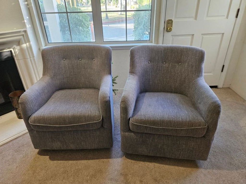Pair of gray tufted accent chairs with curved backs, shown together in good condition on hardwood.  