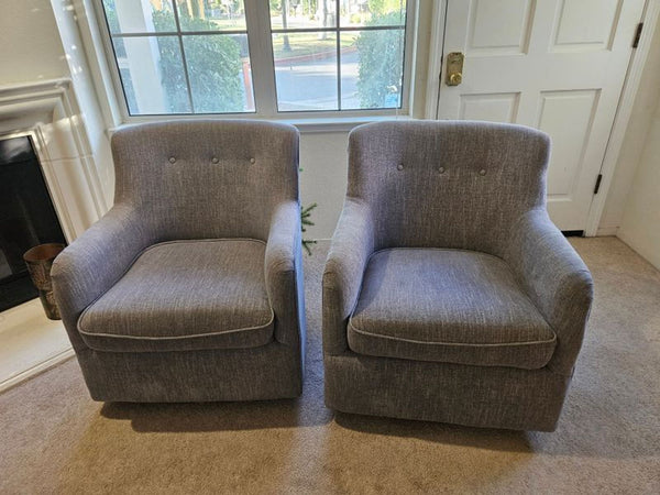 Pair of gray tufted accent chairs with curved backs, shown together in good condition on hardwood.  
