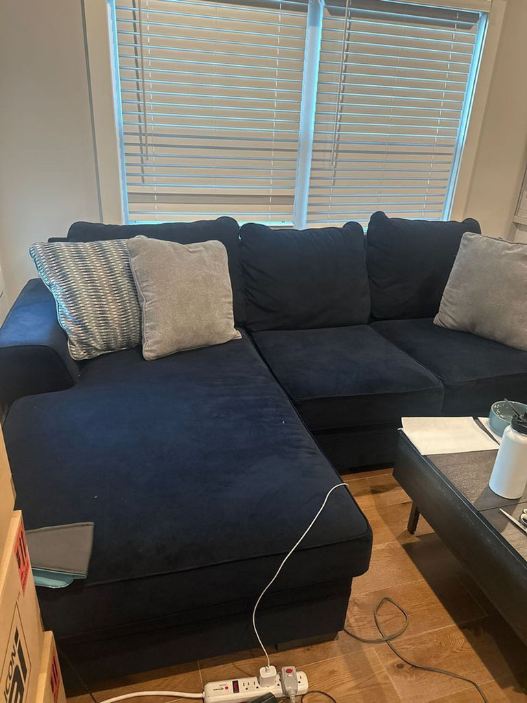 1. Blue sectional sofa with grey pillows, placed by a window in a cozy living room setting.