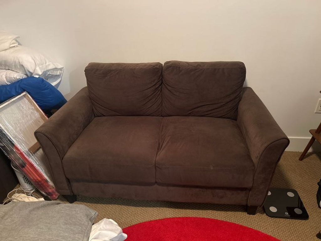1. Modern loveseat with cushioned seats and armrests, upholstered in neutral fabric, ideal for living rooms.