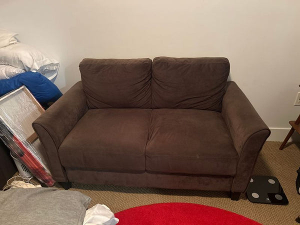 1. Modern loveseat with cushioned seats and armrests, upholstered in neutral fabric, ideal for living rooms.