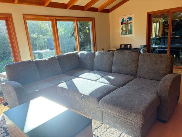 L-shaped sectional sofa featuring pull-out bed and built-in storage compartment.  