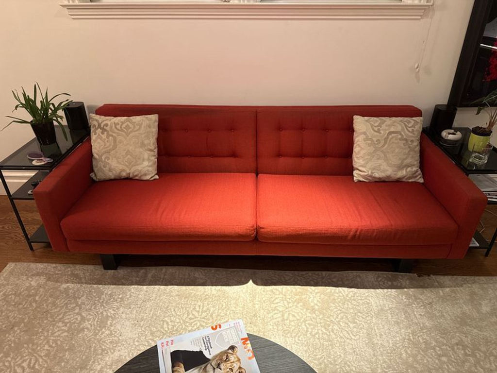 1. Red Room & Board 3-seat sofa with tufted backrest and two patterned pillows in a modern living room.