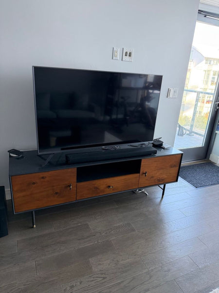 Mid-century modern entertainment center by West Elm or EQ3, shown with a TV and devices on top.