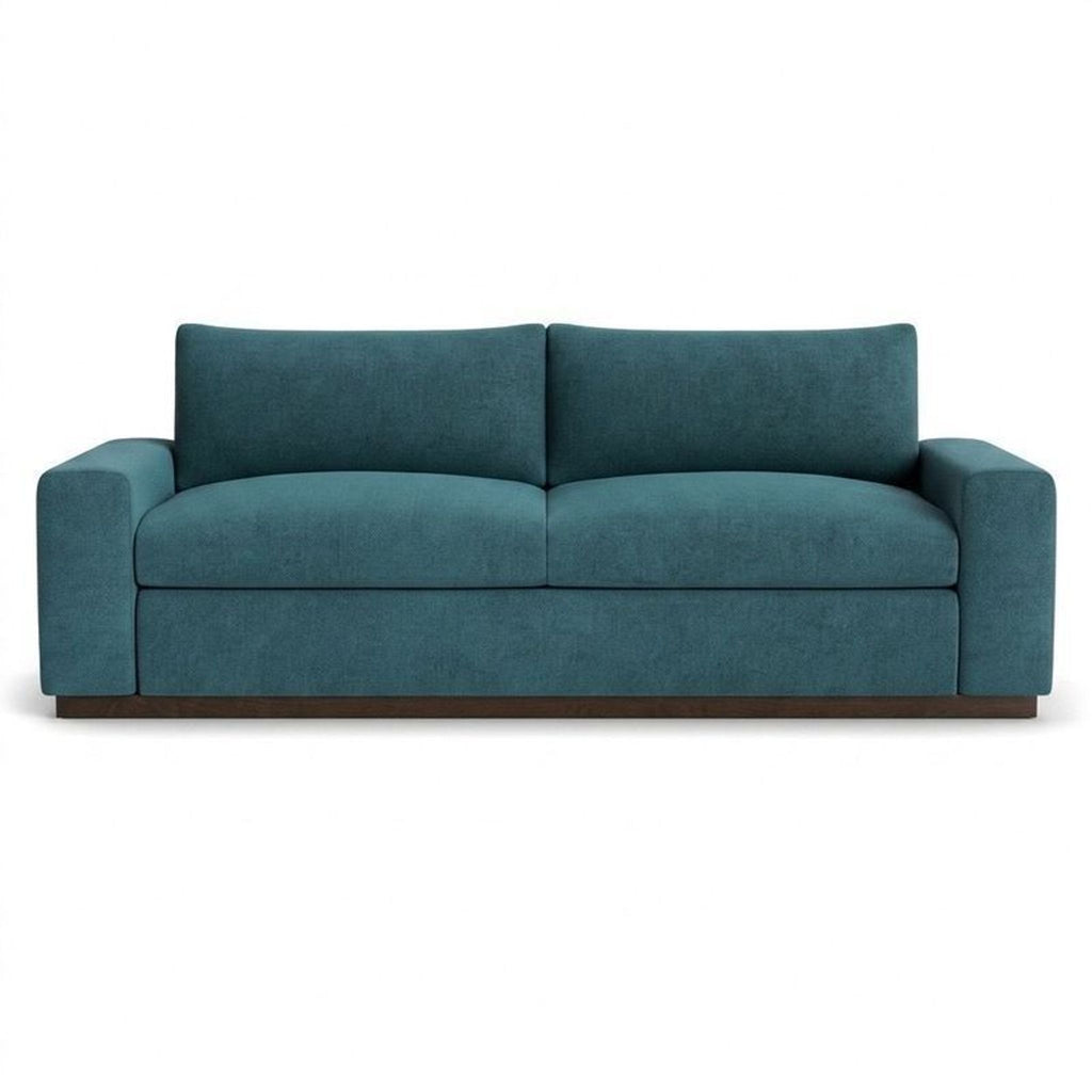 Joybird brand blue velvet loveseat sleeper sofa features plush cushioning and a stylish, boxy silhouette.