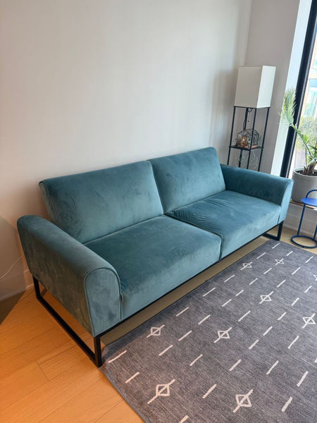 Teal velvet 3-seat couch that folds out into a full-size bed.