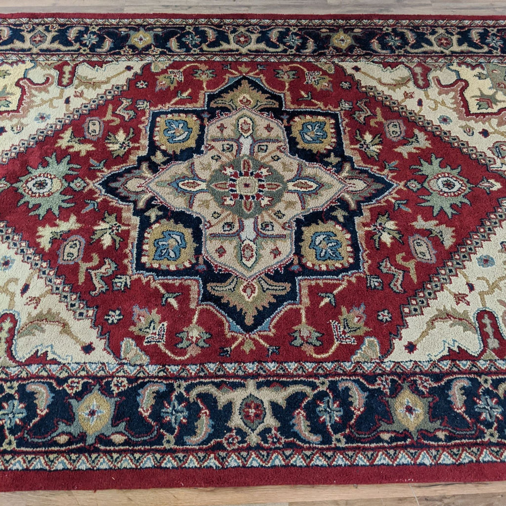 2. Close-up of center detail on Safavieh red Heriz wool rug, showing ornate geometric and floral patterns.