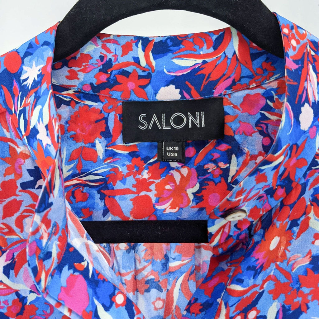 Close-up of Saloni branded label on a floral fabric with vivid colors, detailing UK10/US6 sizing.