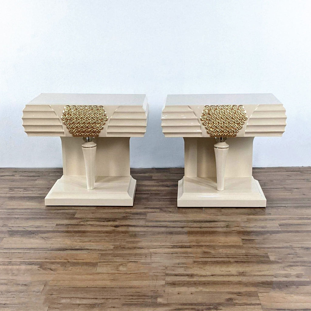 Pair of cream end tables with gold accents on a wooden floor.