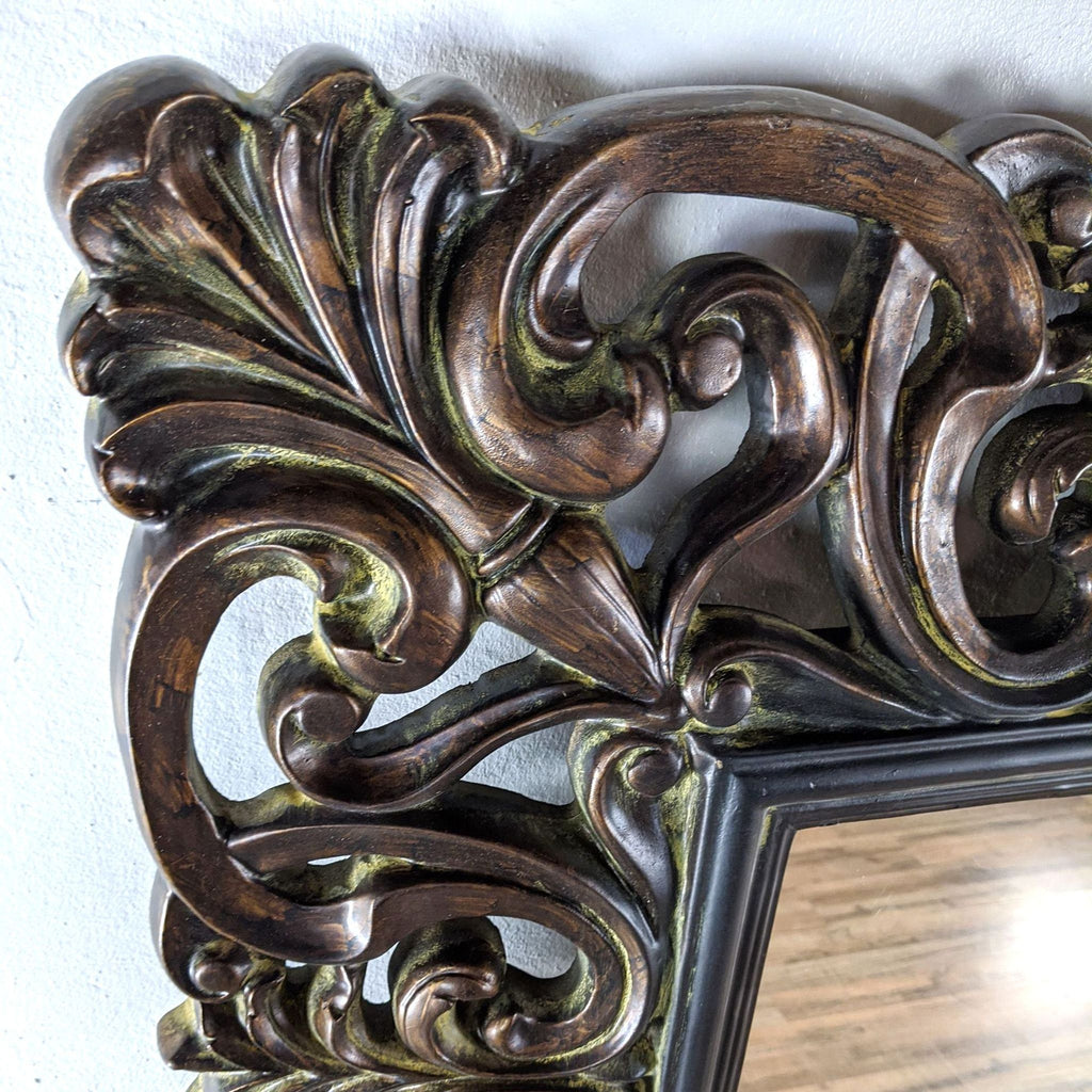 Close-up of a traditional vine pattern carved into the mirror's brown wooden frame.
