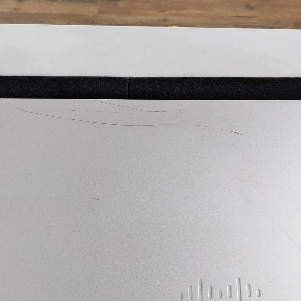 Close-up of the top surface of a Cisco & Bros. networking device, highlighting minor scratches.