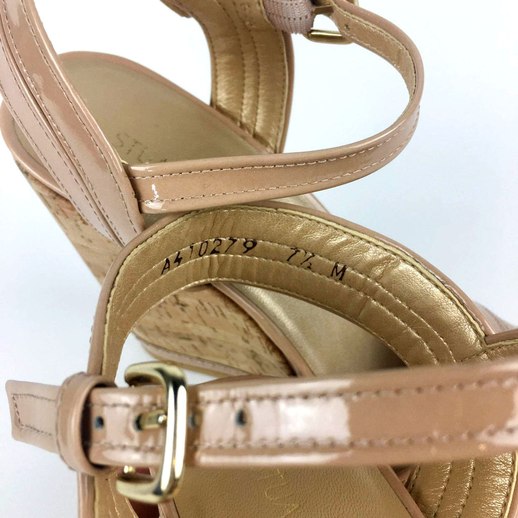 Close-up of patent leather wedge straps and cork heel.