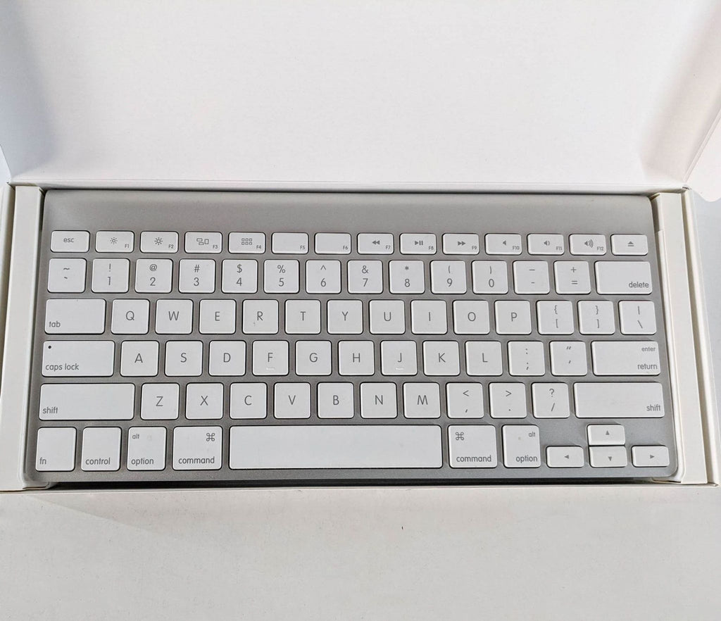 An Apple wireless keyboard in its open packaging, showing a sleek and compact design.
