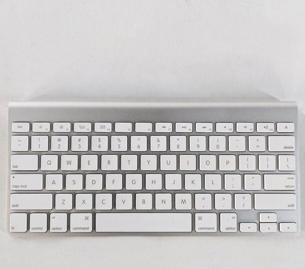 Apple wireless keyboard with white keys and aluminum finish on a white background.