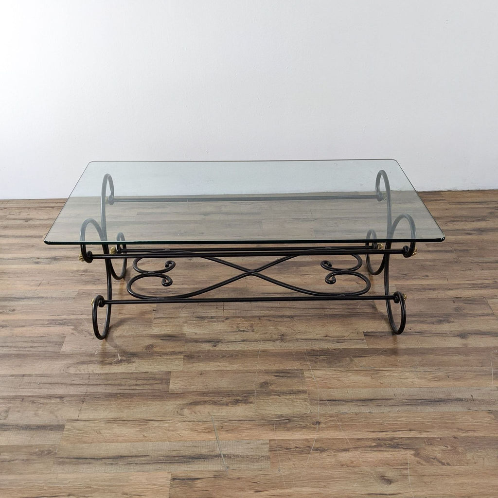 Reperch coffee table featuring a metal scroll design and brass detail under a glass top.