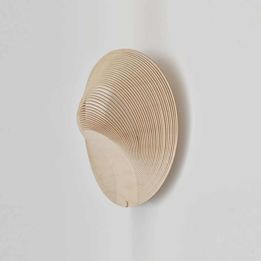 2. Modern Reperch lighting fixture with a sculpted, wooden, circular form mounted on a white wall.