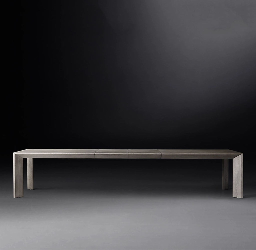 Sleek, modern rectangular dining table with clean lines and a minimalist gray wood finish, set against a dark background.  