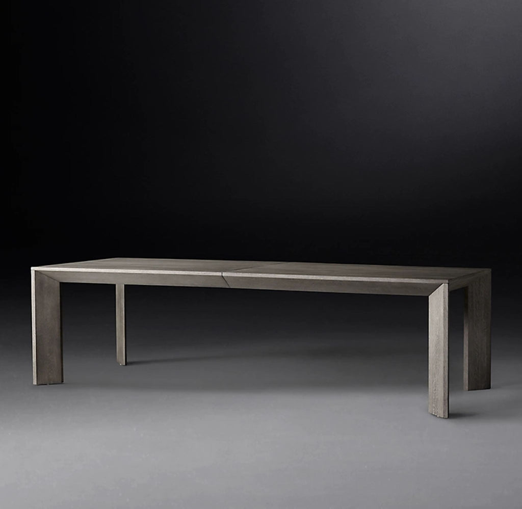 Contemporary gray wood dining table with a long, expandable design and angular legs, shown on a neutral backdrop.