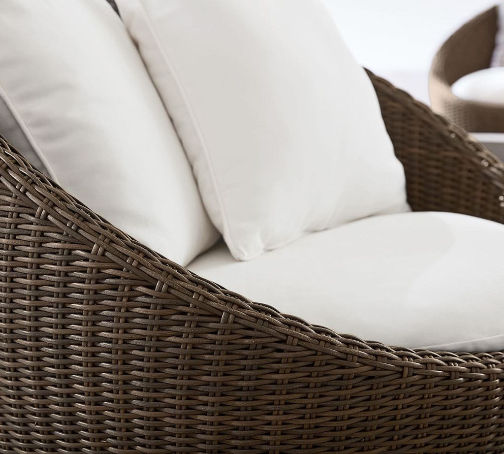 2. Close-up of a brown woven outdoor chair featuring smooth, plush white cushions for extra lounging comfort.