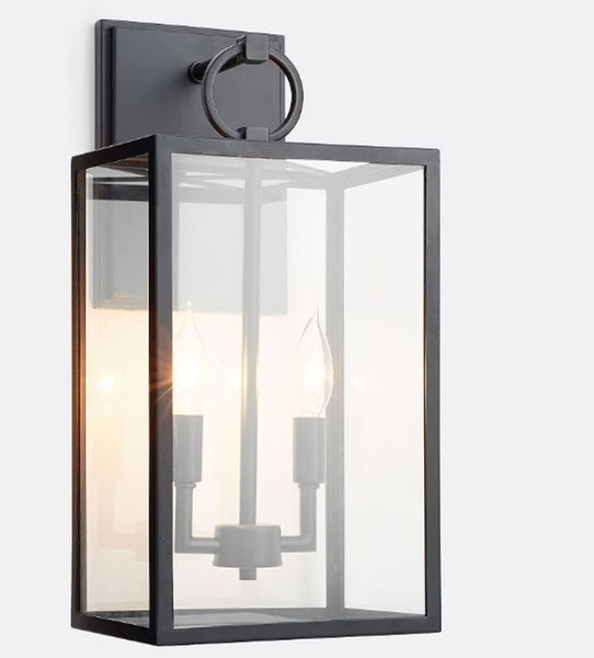 1. Bronze-finished wall sconce with clear glass panes from Pottery Barn, showcasing two visible candle-style lights inside.