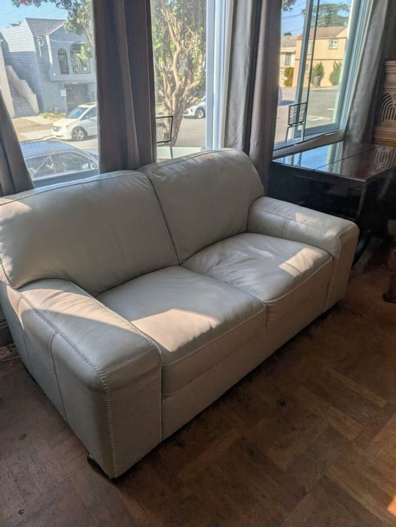 2. Reperch loveseat in a bright room, featuring light upholstery with plush seating and broad armrests.