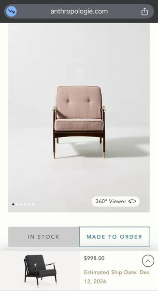 1. Anthropologie lounge chair with beige cushions, wooden frame, and brass accents, photographed on a white background.