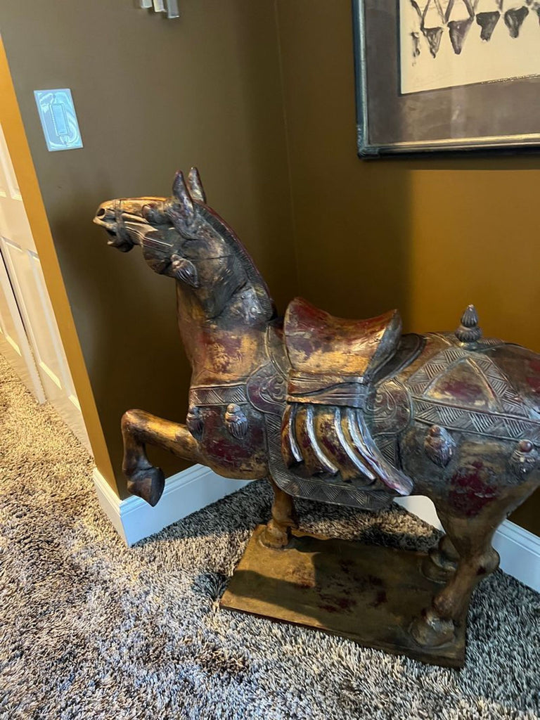 3. "Ornately detailed Reperch Chinese horse statue with gilding, placed on a patterned carpet in a warmly lit room."