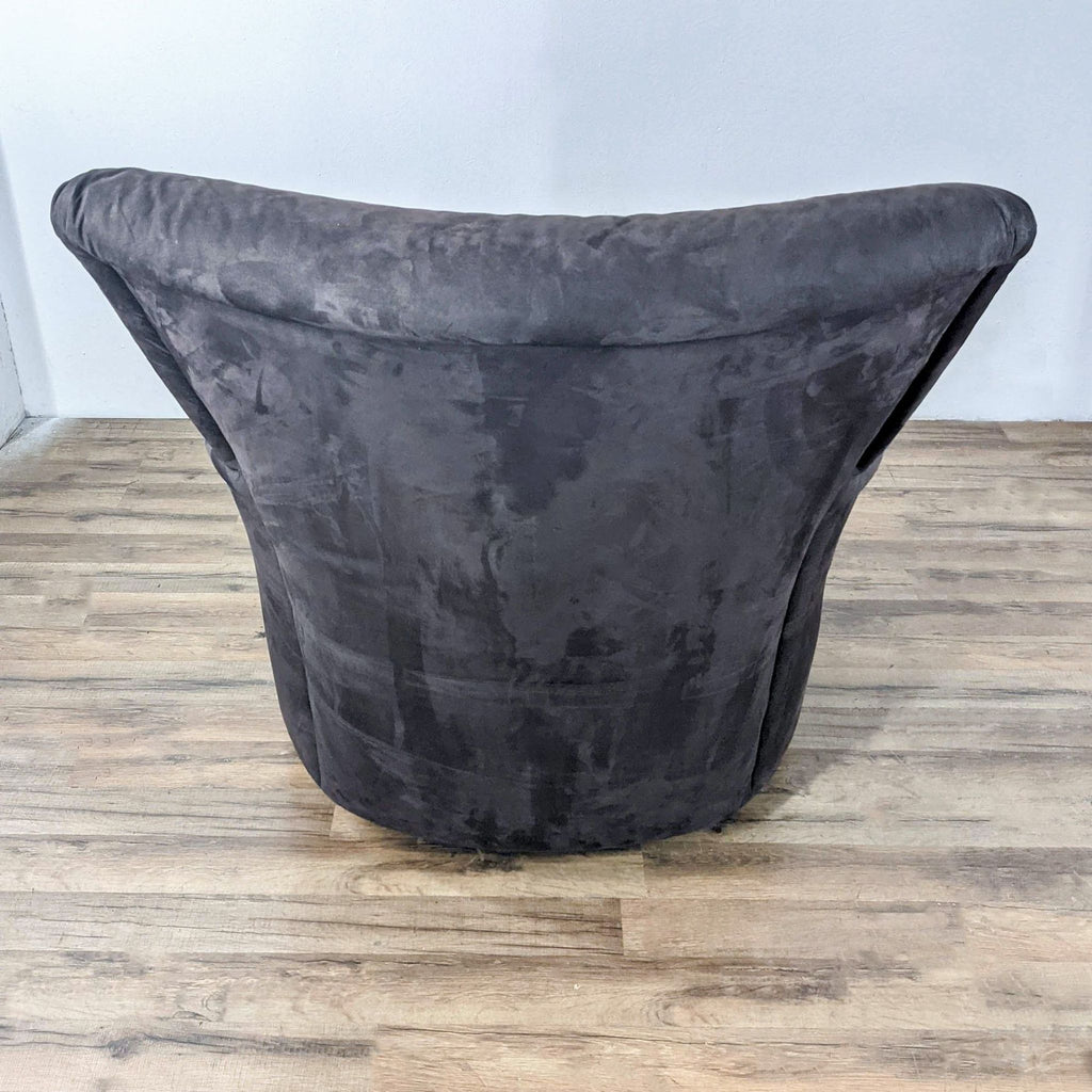 Rear view of a Reperch charcoal suede swivel lounge chair in a room.