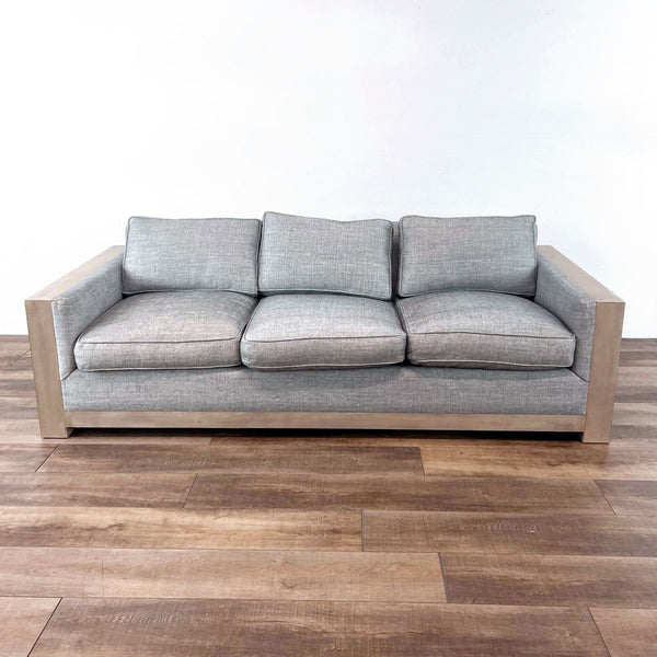 Three-seat Reperch sofa with gray fabric and wooden frame, front view on wooden floor.