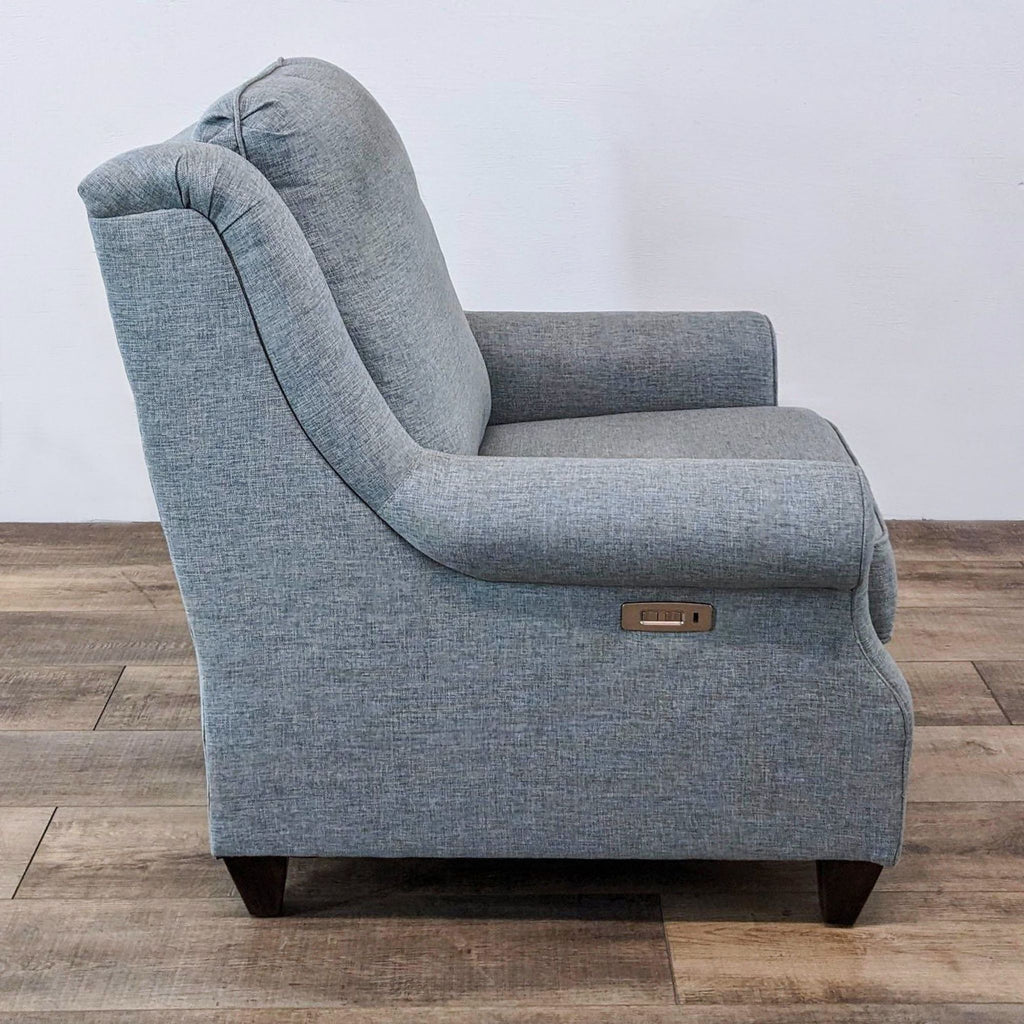 A single gray Bassett Furniture Magnificent Motion power recliner showing side controls.