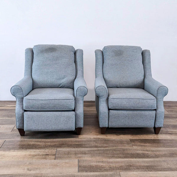 Two gray Bassett Furniture power recliners with wooden legs on a wooden floor.