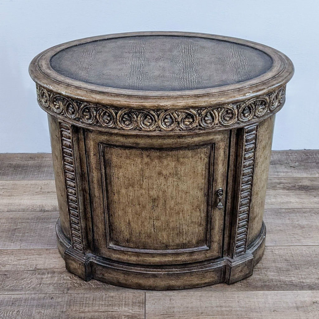 Round antiqued end table with ornate carvings from The Platt Collection.